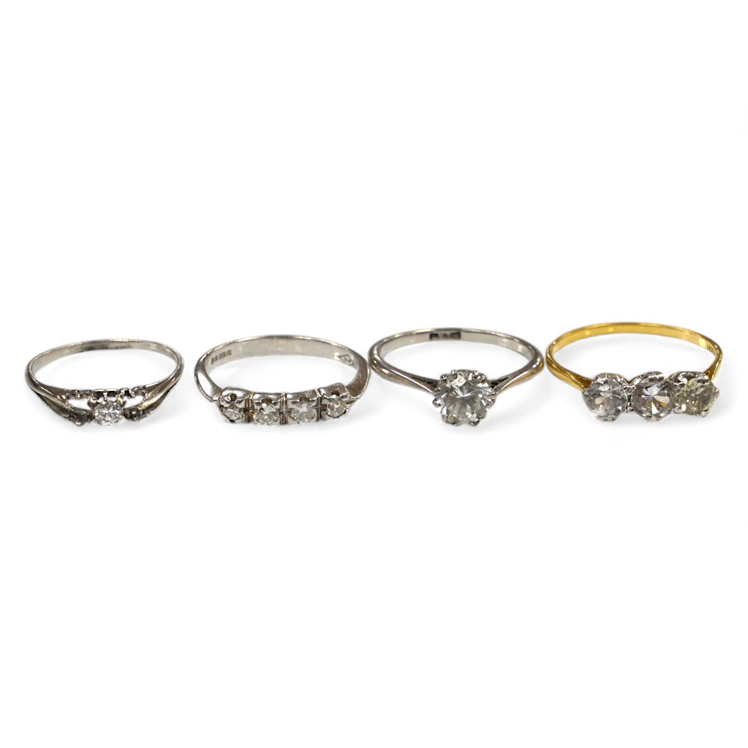 A 9ct gold and four stone diamond set ring, size L, a white metal and solitaire diamond ring and two simulated diamond rings. Condition - poor to fair